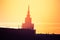 A beautiful silhouette of a tower in city during the sunrise. Morning scenery of Riga, Latvia. Tall building in city.