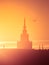 A beautiful silhouette of a tower in city during the sunrise. Morning scenery of Riga, Latvia. Tall building in city.