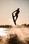 beautiful silhouette of wakeboarder athlete man jumping high making tricks in the air