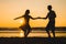 Beautiful silhouettes of dancers at sunset