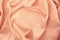 Beautiful silk fabric of delicate doggie color, light pink, draped with small folds, softly flowing, luxurious, wedding concept,