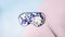 Beautiful silk sleep mask for eyes with flowers pattern and white narcissus or daffodil flower on a pink blue background, panorama