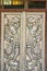 Beautiful silver door leaves with carved silver angels image. Thai style patterned on door leaves made of silver and glass with an