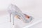 Beautiful silver glitter high heel female shoes on glass shelf. Wedding accessories . Cinderella shoes. Selective focus