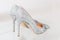 Beautiful silver glitter high heel female shoes on glass shelf. Wedding accessories . Cinderella shoes. Selective focus