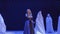 Beautiful singer dances with stranger in cloak on stage in theatre