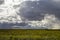 Beautiful sky with dark storm clouds and bright clouds over a rural field