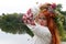 Beautiful slavic girl with long red hair and blue eyes with flower crown in embroidered ethnic suit. Feast of Ivan Kupala