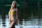 Beautiful slender girl teenager in swimsuit standing in water