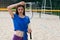 Beautiful slim european woman posing on the beach playing badminton