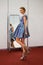 Beautiful slim girl with creative hairstyle posing in front of a mirror, indoors shot. Fashion model at backstage