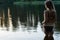 Beautiful slim girl in swimsuit standing in water, back view