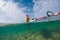 beautiful slim windsurfer girl walking along the sandy bottom