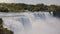 Beautiful slow motion background scenery of epic Niagara Falls waterfall streaming down with foam on a sunny summer day.