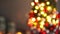Beautiful small Christmas tree of moss on wooden table. Happy mood. Garland lamp bokeh on background. Abstract blur.
