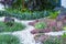 Beautiful small gravel garden, decorated with white shell, brown stone, colorful ground cover plant and green shrubs