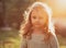 Beautiful small kid girl thinking in sunset sun light on summer bacground. Closeup