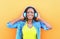 Beautiful smiling african woman with headphones enjoying listens to music