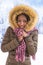 Beautiful smiling African woman wearing a fur coat and hood over snow in winter day