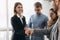 Beautiful smiling businesswoman and businessman handshaking standing in office, nice to meet you, first impression, being promoted