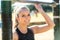 Beautiful smiling and cheerful portrait of a female athlete, exercising in city park with outdoor pull up bar course equipment