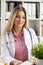 Beautiful smiling female doctor sit at workplace