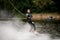 beautiful smiling female wakeboarder riding on wakeboard on river water