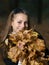 Beautiful smiling girl with armful of leaves