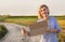 Beautiful smiling girl gets hitchhiked and votes with a sign of cars on a rural road in the rays of the sunset