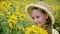 Beautiful smiling girl posing with yellow sunflowers in countryside