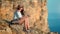 Beautiful smiling hiker female relaxing on top of mountain enjoying natural view at sunset