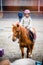 beautiful smiling little girl on her pony taking a riding lesson