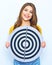 Beautiful smiling model holding round target of darts