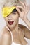 Beautiful smiling model wearing a yellow sleep mask