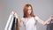 Beautiful smiling redhead girl with a lot of shopping bags.