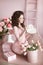 Beautiful smiling teen girl portrait open present, romantic surprise. Brunette in pink dress over bouquet of flowers and gift box