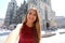 Beautiful smiling tourist girl taking self portrait with smartphone in Vienna with Saint Stephen`s cathedral on the background in