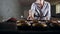 Beautiful smiling woman confectioner putting tray with raw tartles in patterns. View from oven inside. Modern kitchen