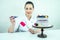 Beautiful and smiling woman confectioner in white work uniform adorns the cake in the kitchen. confectioner, cake