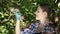 Beautiful smiling woman at garden looking at apples