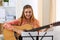 Beautiful smiling woman holding and playing western acoustic gui