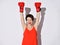 Beautiful smiling woman with short hair in red top and red boxing gloves standing with raised hands, feeling happy with victory