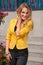 Beautiful smiling woman with yellow jacket and blond hair posing outdoor. Fashion girl