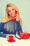 beautiful smiling young female sitting near the table and speaking with vintage telephone smiling looking at camera instagram