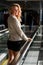 Beautiful smiling young woman looking back while standing on travelator