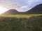 Beautiful snow cliffs mountain and hills in Fljotavik cove, Hornstrandir, west fjords, Iceland, with green grass meadow