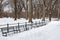 Beautiful Snow Covered Long Row of Benches at Central Park in New York City during the Winter