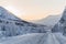 beautiful snow covered winter road with road sign and trees in mountains,
