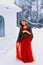 Beautiful snow maiden girl with red hair on february nature. Snow fall in february. Long retro gown