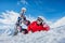 Beautiful snowboard girl lies on the snow looking at the camera.